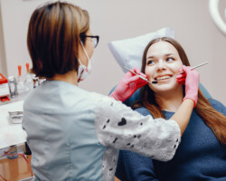 Girl talking to the dendist. Beautiful lady in the dentist's office. Woman in a uniform